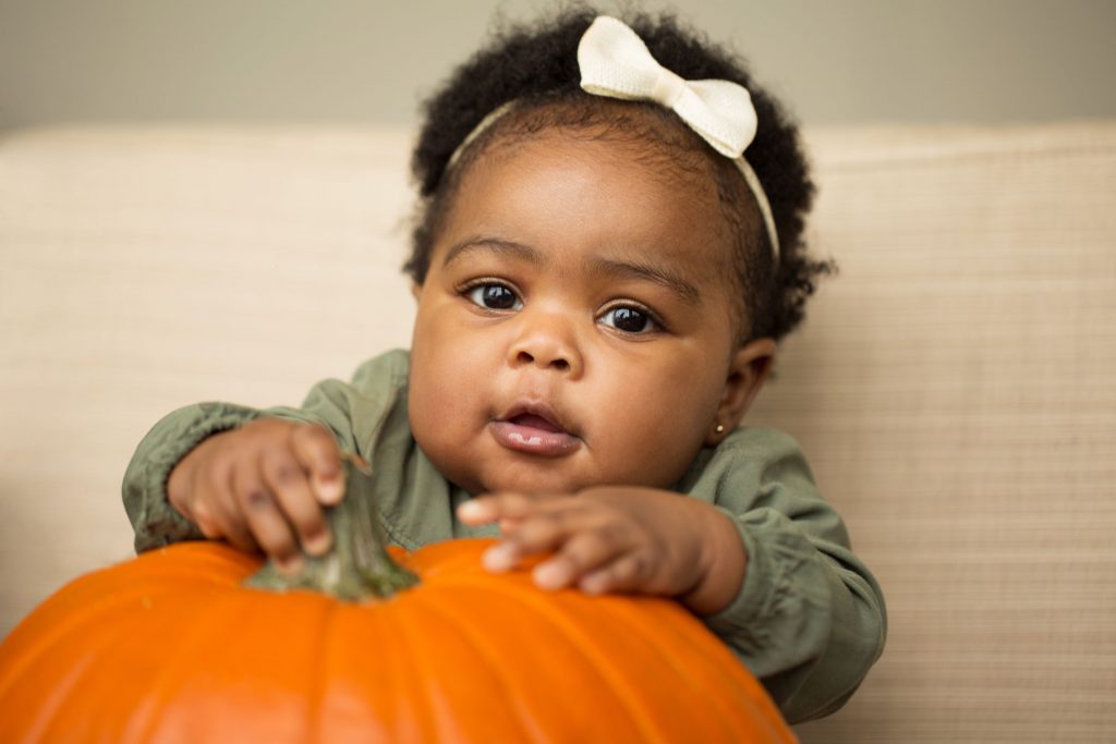 Cute African American Girl With Pumpkin.